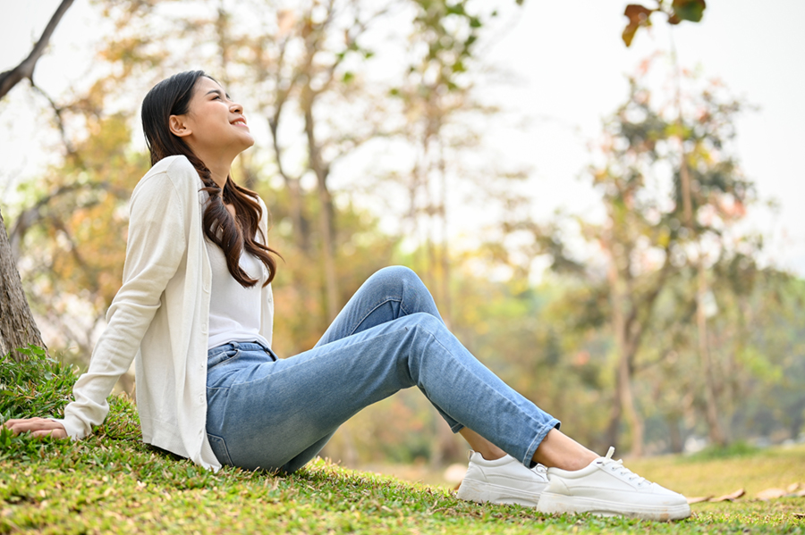 Young happy woman sitting in park