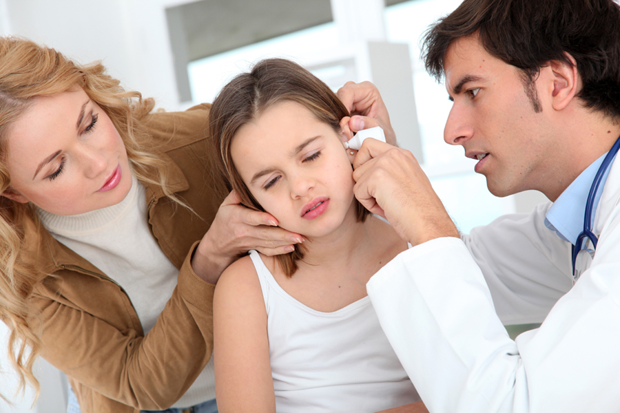 Doctor looking at girl ear infection