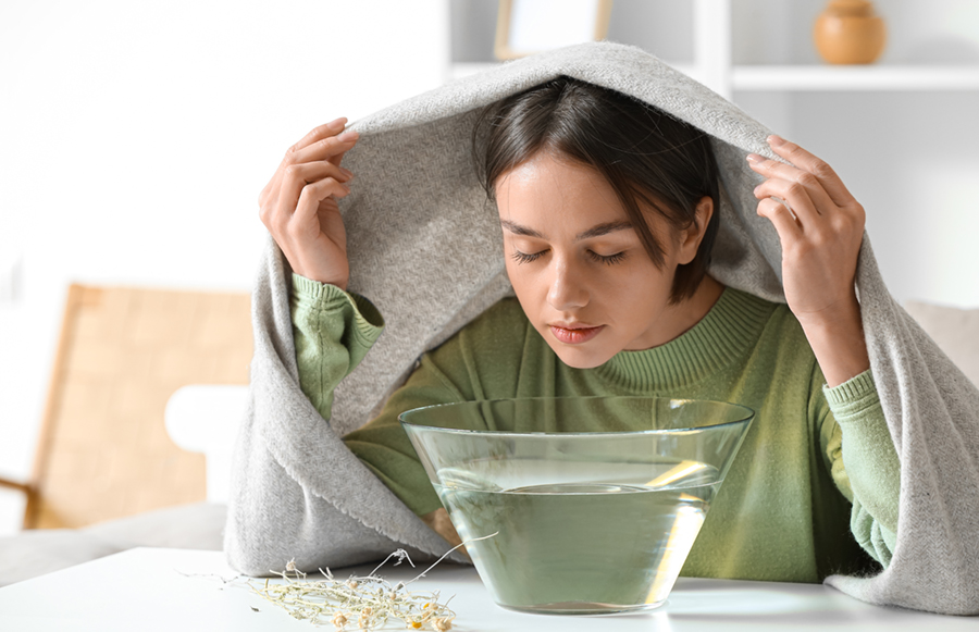 Young woman doing steam inhalation at home to soothe and open nasal passages