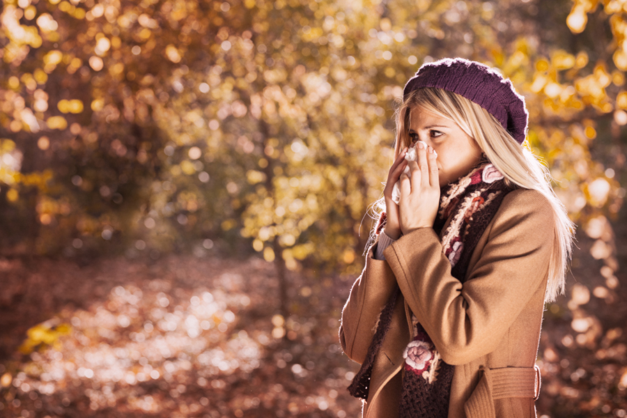 Girl with cold rhinitis on autumn background.