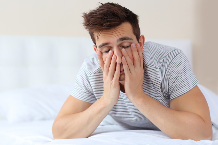 Tired man having trouble getting out of bed